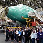 Group of people in front of an airplane under construction