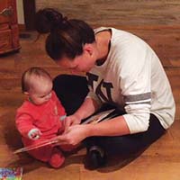 Woman showing a book to a baby